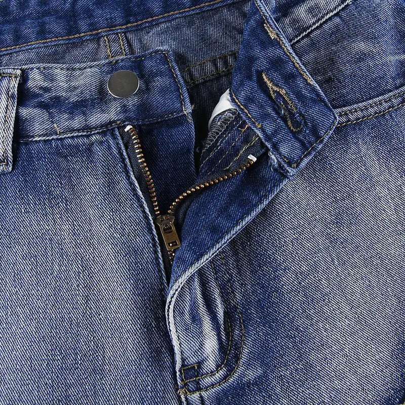 Detailed view of the zip fly and button closure on rugged denim fabric.