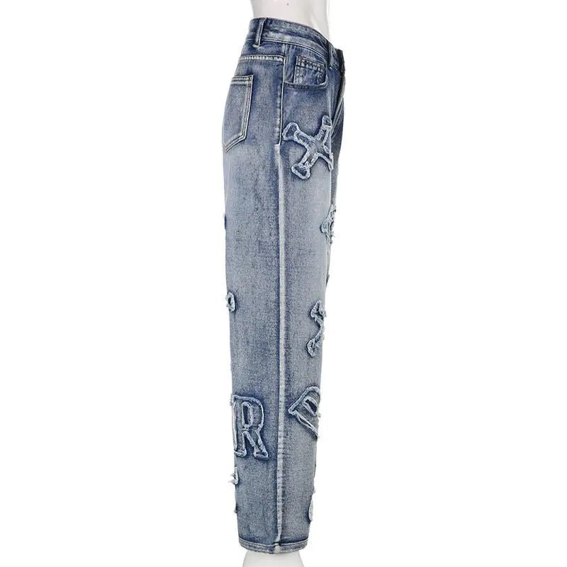 Side view of denim jeans featuring prominent frayed alphabet patches and classic side pocket.