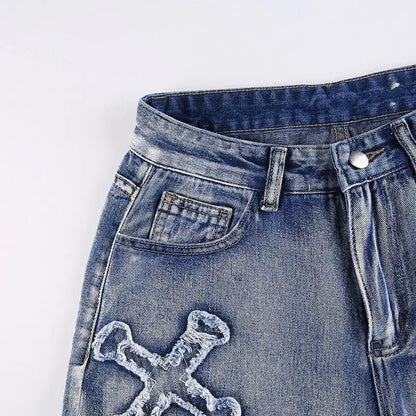 Close-up of the front waistband and pocket stitching on distressed denim jeans.