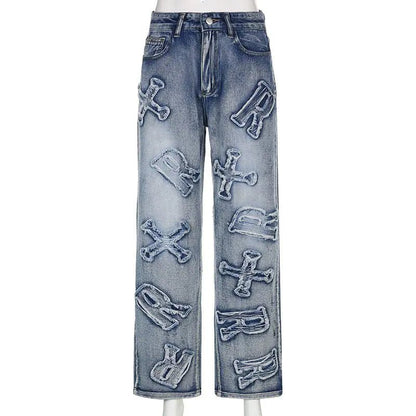 Front view of blue straight-leg jeans with large distressed alphabet letter appliqués.