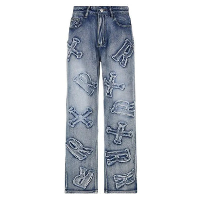 Front view of blue straight-leg jeans with large distressed alphabet letter appliqués.