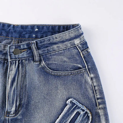 Close-up of the front waistband and pocket stitching on distressed denim jeans.
