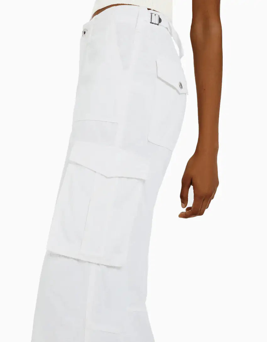 side view of white utility cargo trousers with large side pockets and high-waist fit, worn with platform sandals.