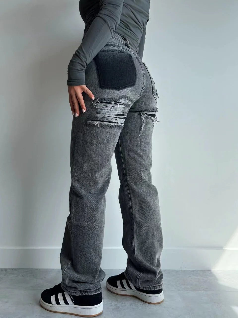 Casual gray ripped jeans with contrast pocket detail, styled with a fitted top and sneakers