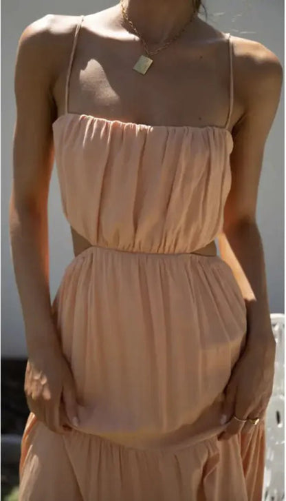 Close-up of a peach open waist flared dress showing ruched bodice and side cut-out detail.