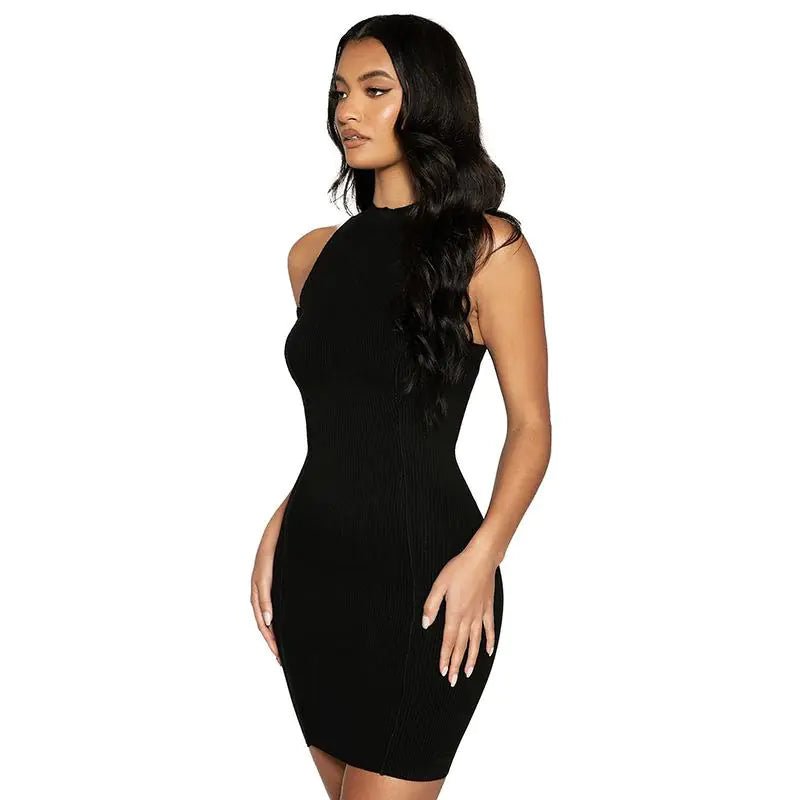 Woman wearing a sleeveless black ribbed halter mini dress with a fitted silhouette, posing confidently.