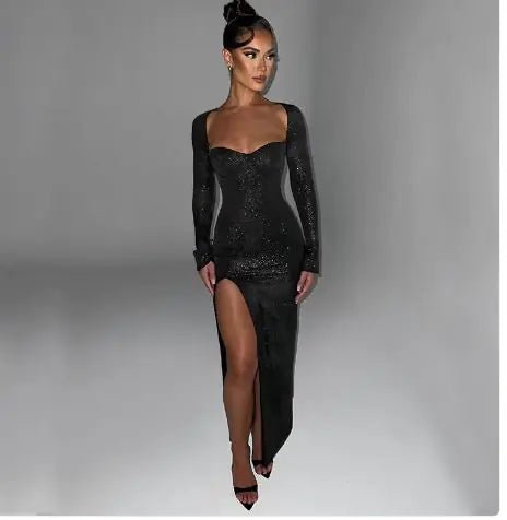 Elegant woman wearing a sparkly black long sleeve evening dress with a sweetheart neckline and thigh-high slit.