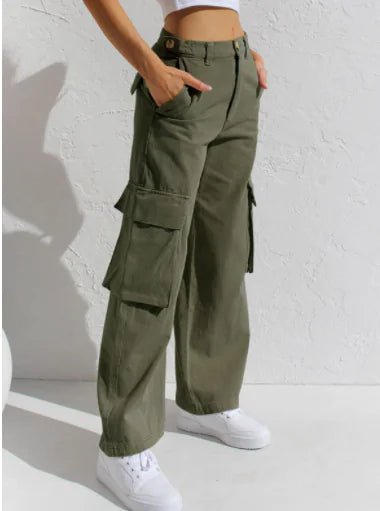Close-up of olive green utility trousers with side cargo pockets, styled with white sneakers against a plain white backdrop.