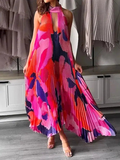 "Sleeveless A-line pleated dress in red, pink, and navy floral print with halter-style top and keyhole front cutout."