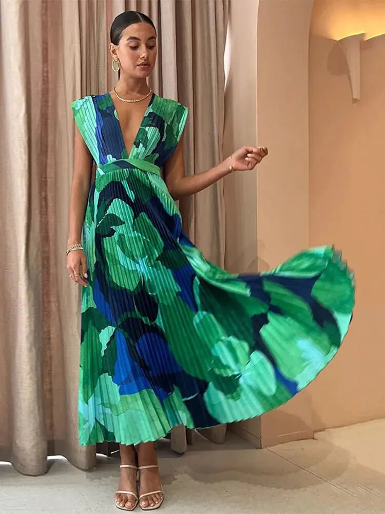 "Elegant long-sleeve pleated maxi dress with a bold green and blue abstract floral print, featuring a deep V-neckline and relaxed fit."