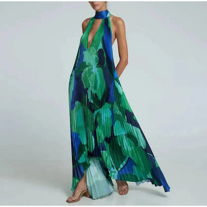 "Flowy sleeveless maxi dress with green and blue abstract floral print, featuring a deep V-neck and halter neckline."