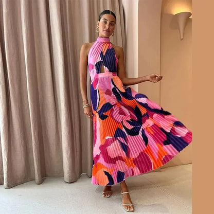 "Vibrant pink and purple sleeveless pleated midi dress with halter neckline and bold abstract floral pattern."