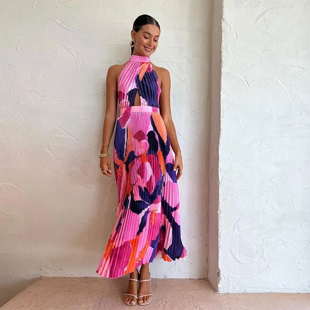 "Vibrant pink and purple sleeveless pleated midi dress with halter neckline and bold abstract floral pattern."