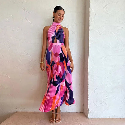 "Vibrant pink and purple sleeveless pleated midi dress with halter neckline and bold abstract floral pattern."