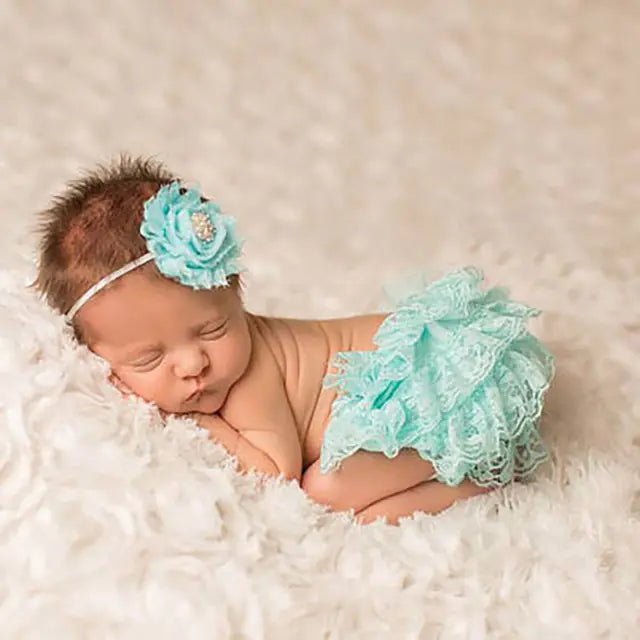"Newborn baby in aqua blue lace bloomers with matching flower headband"