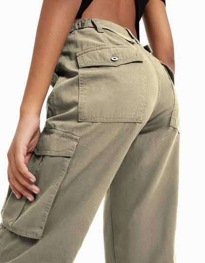 Close-up back view of olive green cargo trousers with flap pockets and seam detailing.
