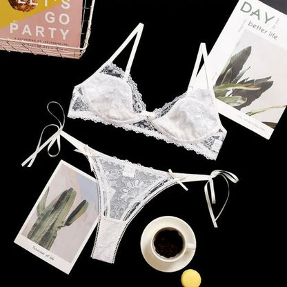Flat lay of a white lace sleepwear set on a black background with lifestyle elements