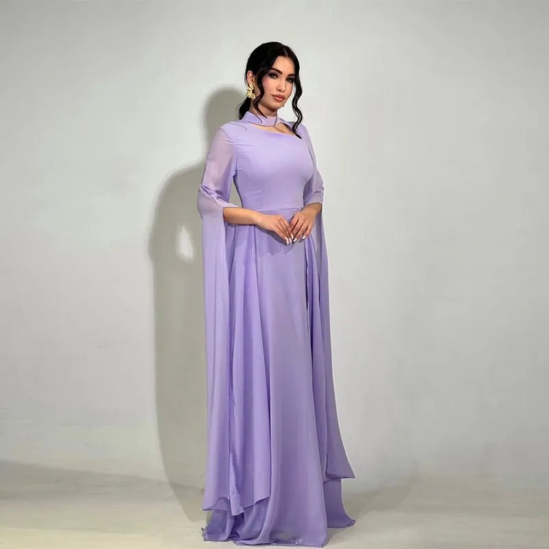 Graceful woman in a soft lilac slim-fit long dress with translucent cape sleeves and minimal jewelry.