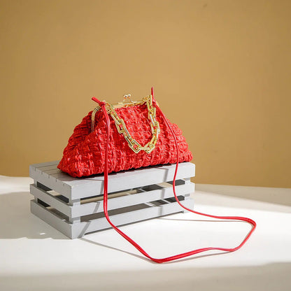Red pleated handbag with gold chain and red shoulder strap.