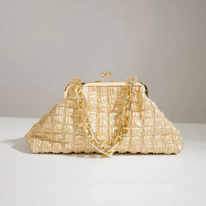 Beige pleated handbag with gold chain set on white surface.