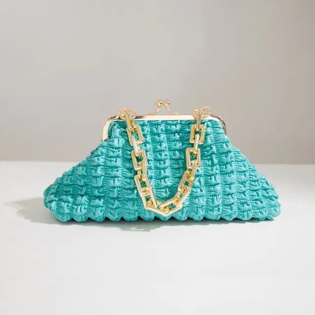 Light blue pleated handbag with gold chain shown on a white platform.