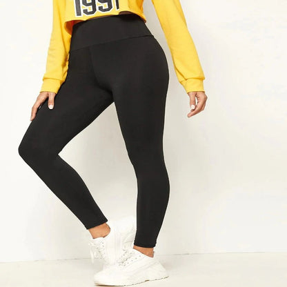 Woman wearing a yellow sweatshirt with 'New York 1991' print and black leggings, perfect for yoga, sports, or casual wear."

