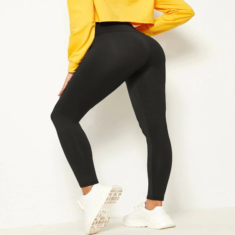 Back view of a woman wearing black leggings and a yellow sweatshirt, perfect for yoga, sports, or casual activities."

