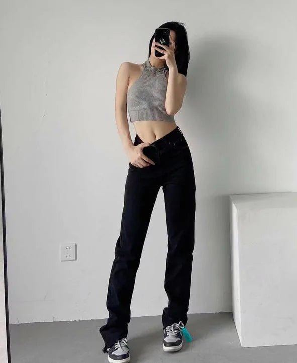 "High-rise sculpting jeans in black, front view styled with crop top and sneakers"