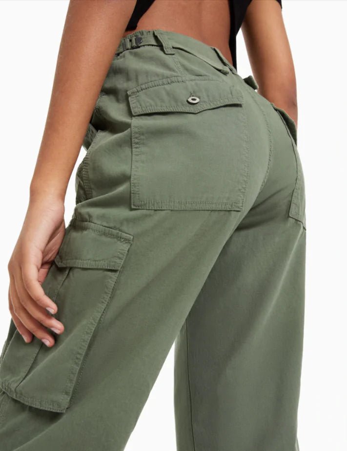 Close-up back view of dark green cargo trousers featuring utility pockets and reinforced stitching.