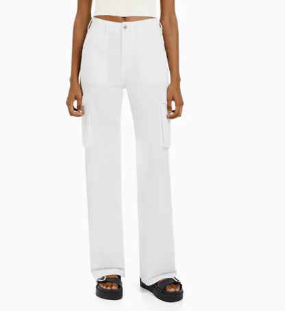 Front view of white utility cargo trousers with large side pockets and high-waist fit, worn with platform sandals.
